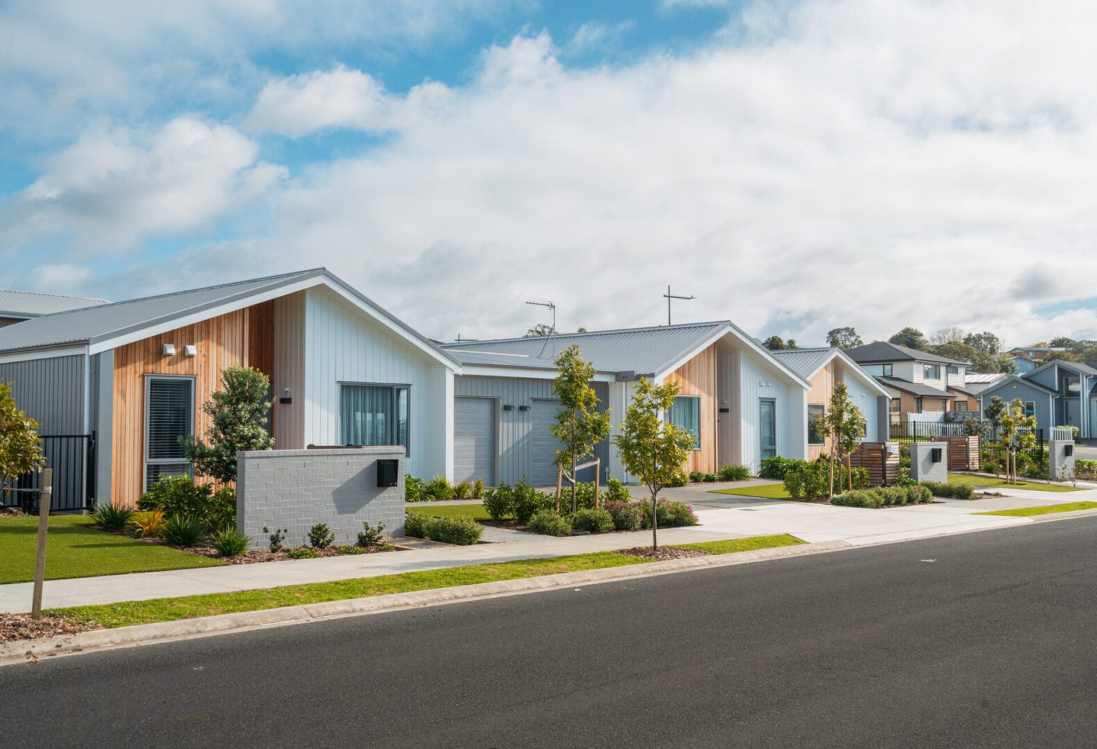 Row of single story newly developed modern town  houses side the road.